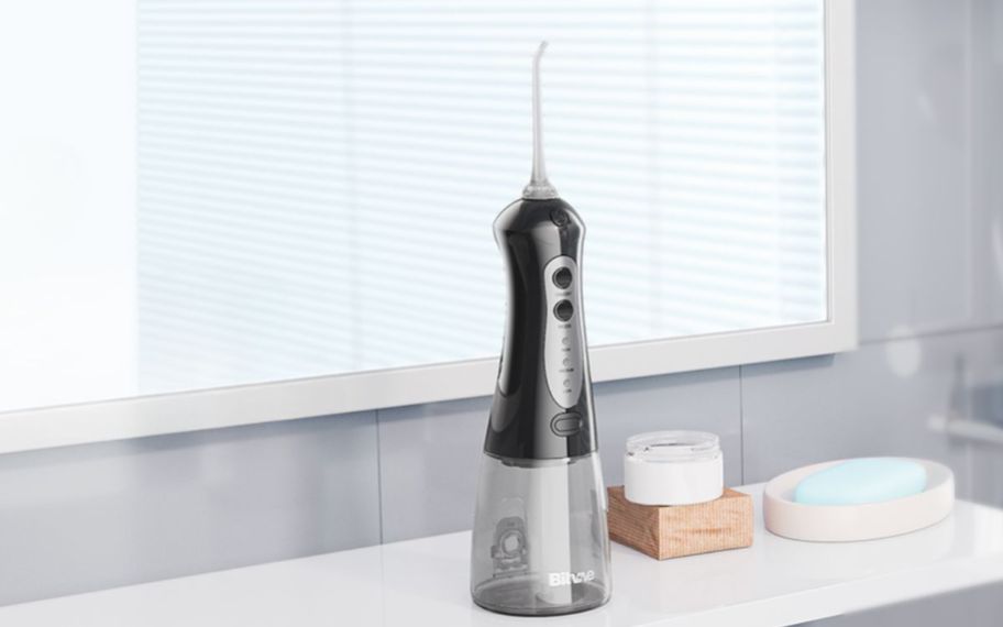 a black water flosser on a bathroom countertop