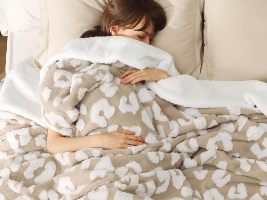 woman sleeping with sherpa printed blanket