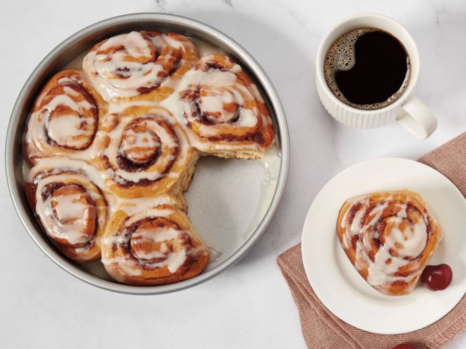 9" Round Cake Pan with cinnamon rolls in it next to a cup of coffee