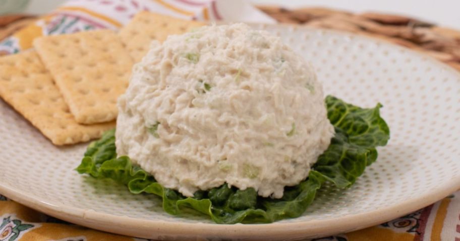 A scoop of Chicken Salad Chick Classic Carol Chicken Salad on a bed of lettuce