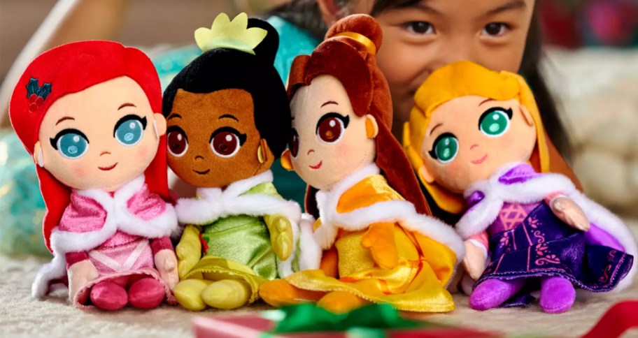 girl laying behind Disney Princess Holiday Soft Doll Set