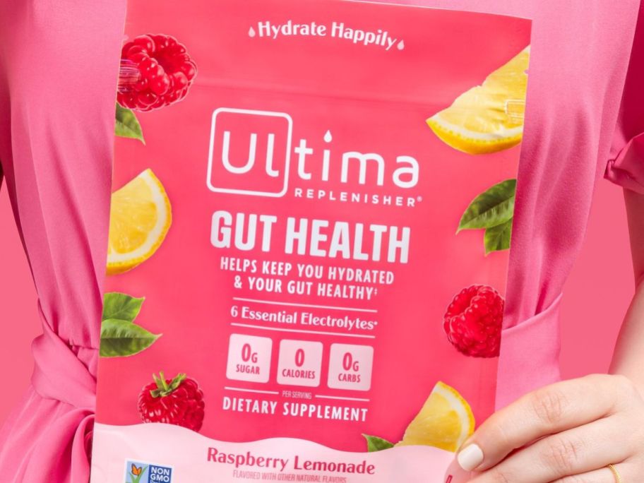 Hand holding a bag of Ultima Replenisher Gut Health