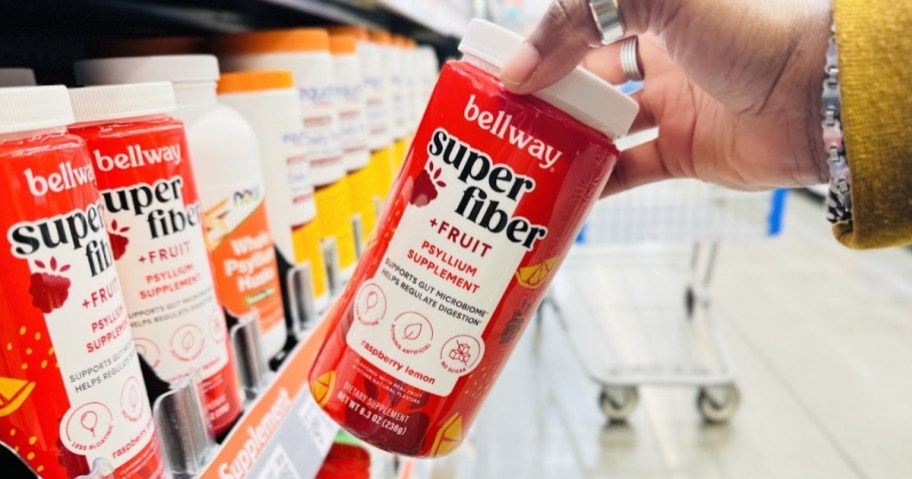 hand pulling a Bellway Super Fiber Powder container off a store shelf with more of them on the shelf