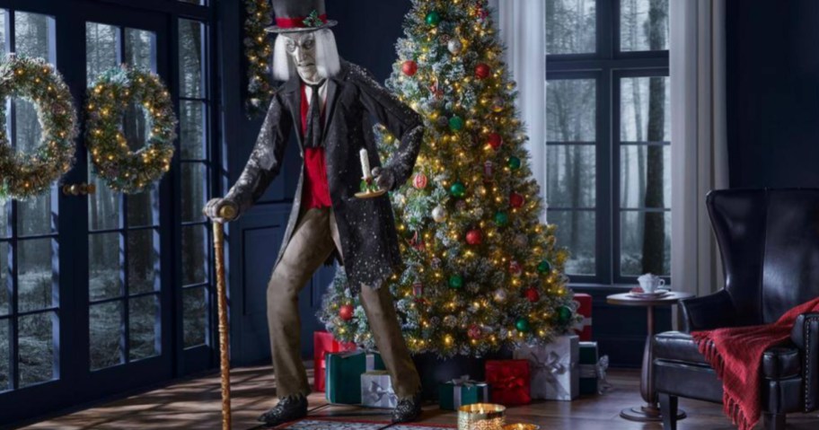 Life-size Scrooge in front of Christmas tree inside home