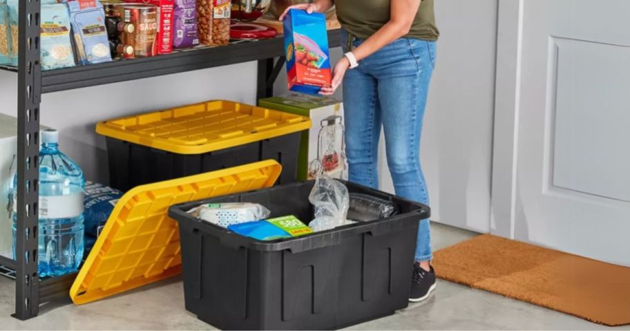 person filling Member's Mark 27-Gallon Heavy Duty Storage Tote in garage