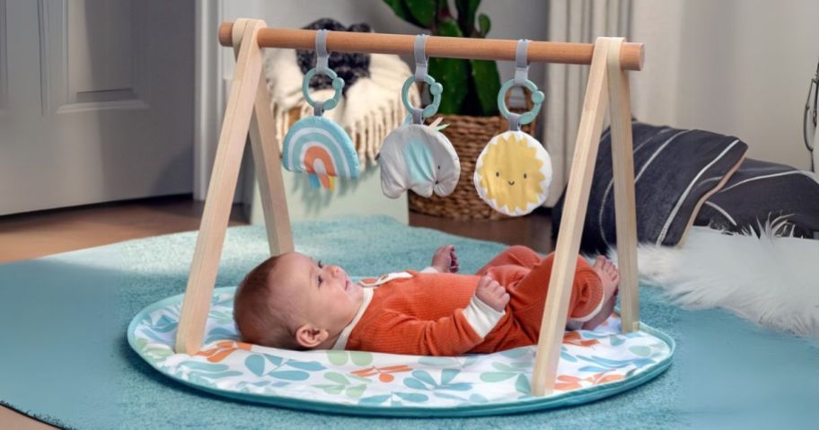 baby playing on Ingenuity Baby Gym in Multicolored