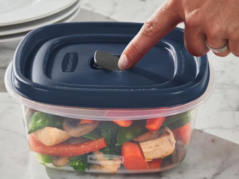 person pressing on Rubbermaid Easy Find Lids Food Storage Container Vented Lid