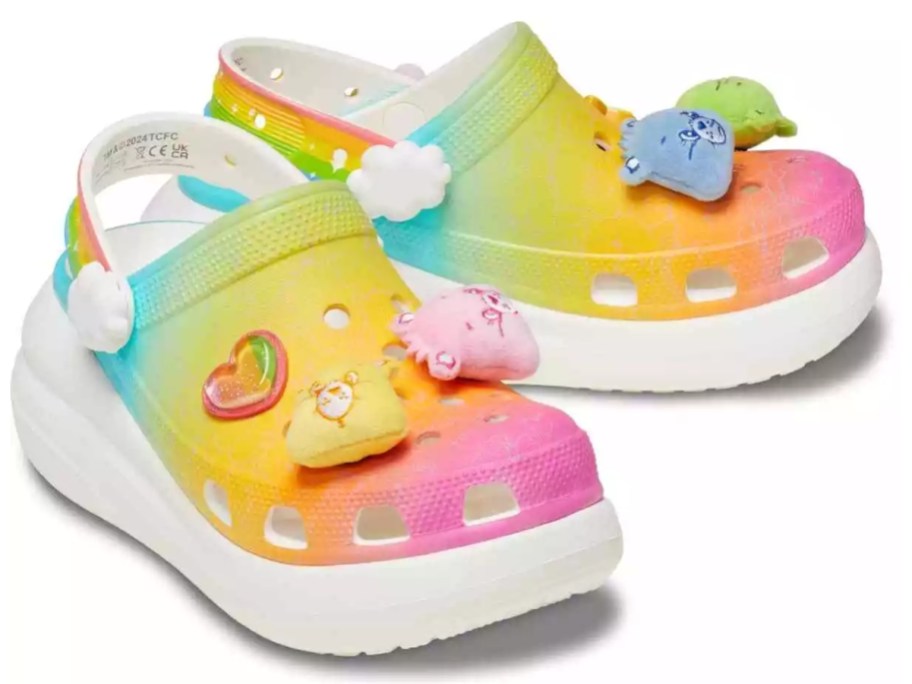 a pair of platform Crocs clog shoes in pink, blue, orange, green, and yellow with Care Bears on them