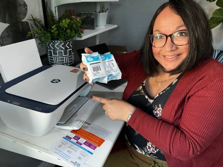 woman holding 2 ink cartridges of HP ink