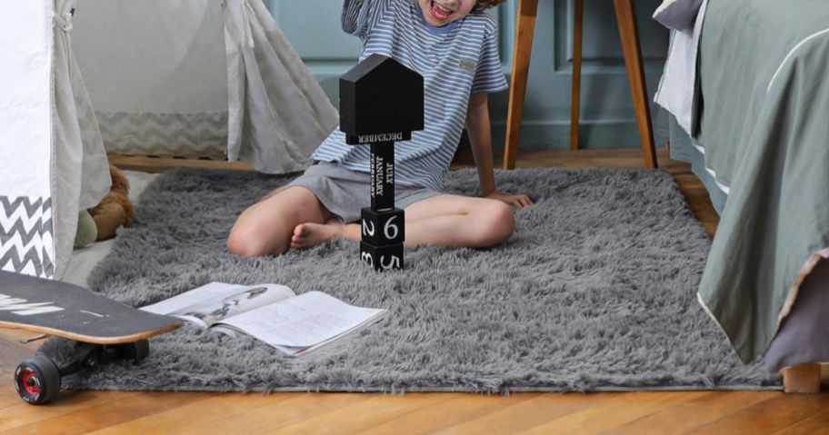 kid sitting on Ophanie 4 x 6 Area Rug in Grey