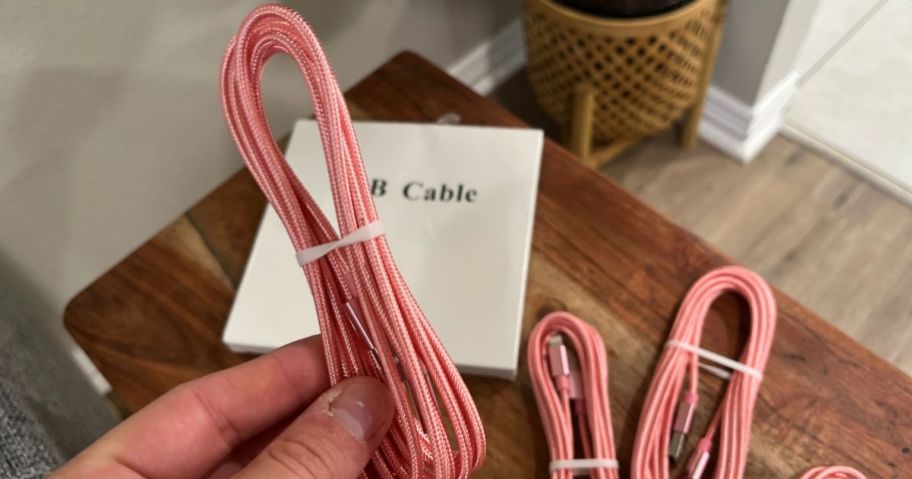 hand holding a pink charging cable