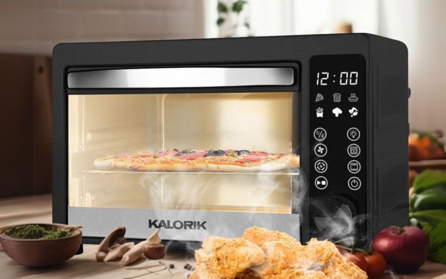 an Air fryer toaster oven baking a pizza on a kitchen counter 