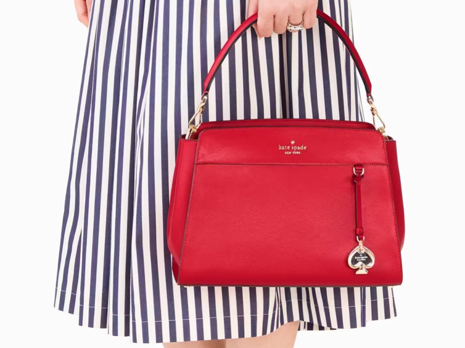 woman in a striped dress holding a red purse