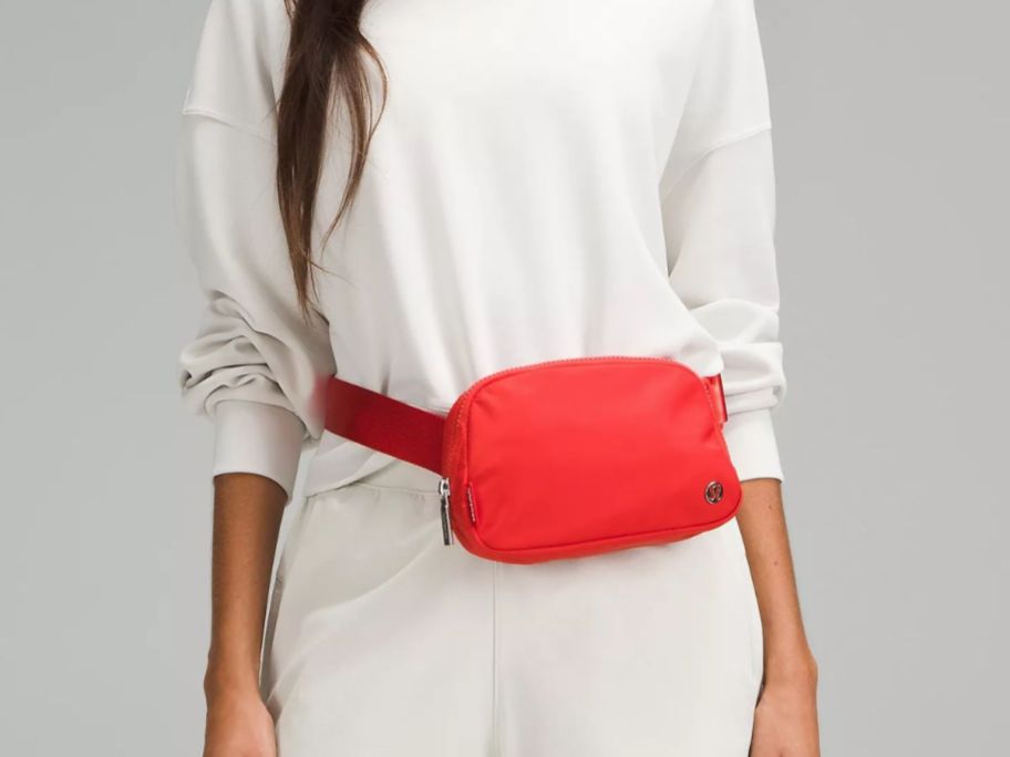 a woman wearing a red lululemon belt bag 