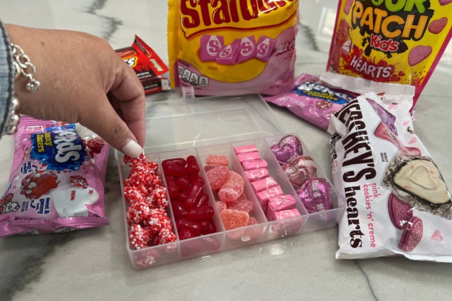 assembling a valentine's day snackle box, or tackle box, filled with candy