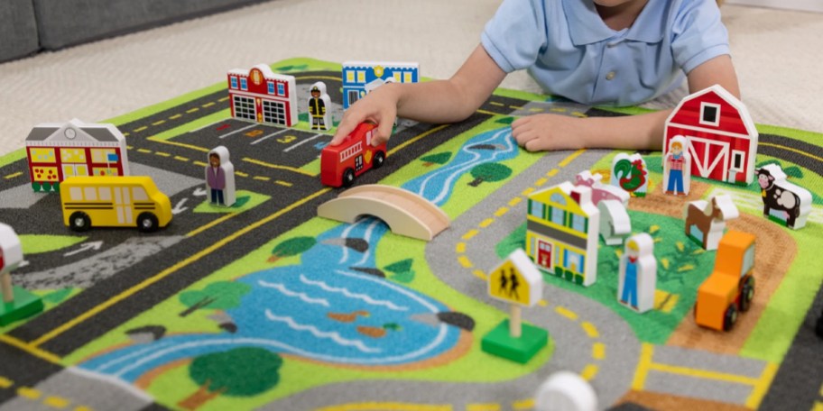 boy playing with wooden toys on rug