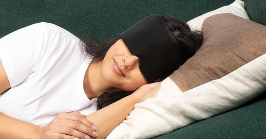 woman laying on couch with migraine cap on