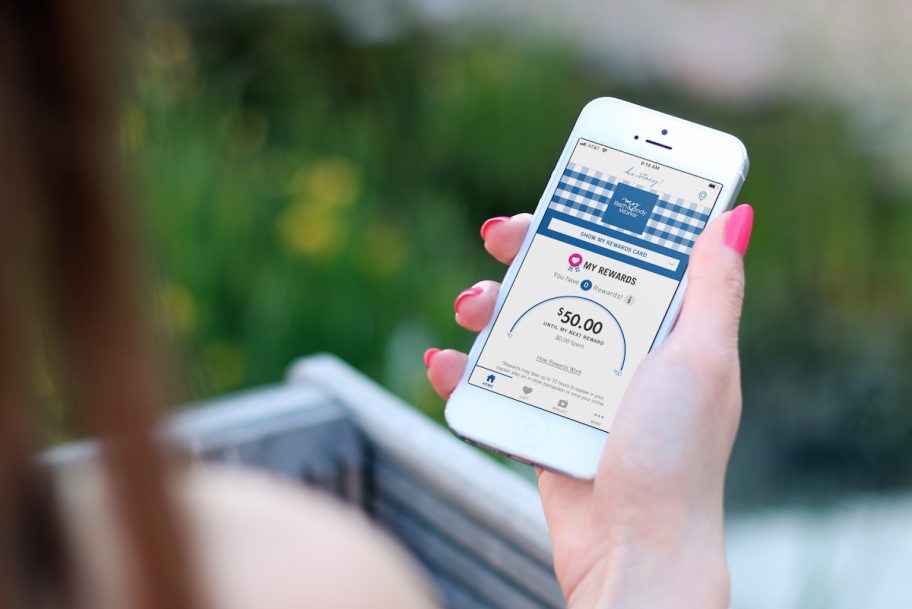 woman holding iphone with bath and body works app on screen