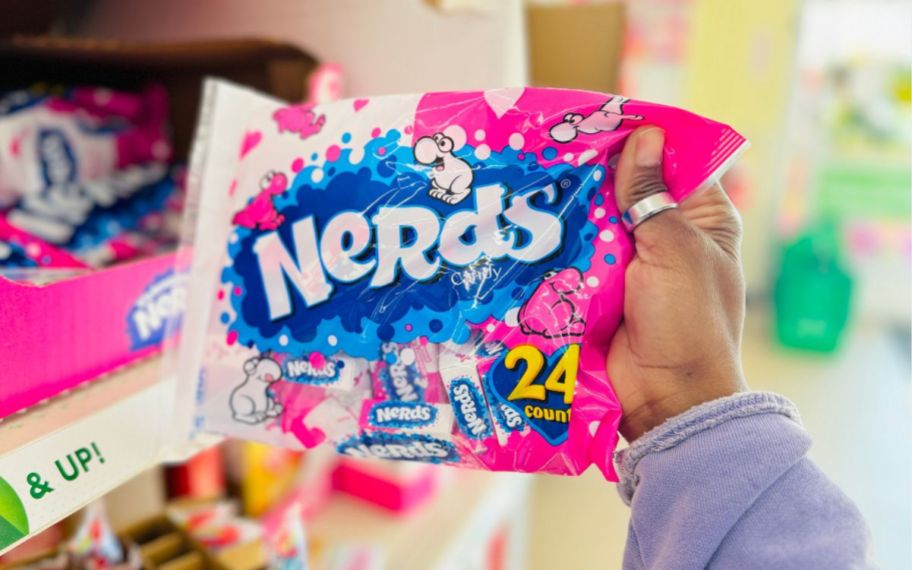 a womans hand holding a bag of valentines day nerds candy