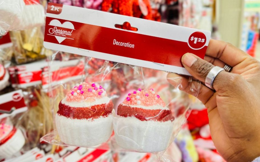 a womans hand holding a bag of valentines cupcake ornaments