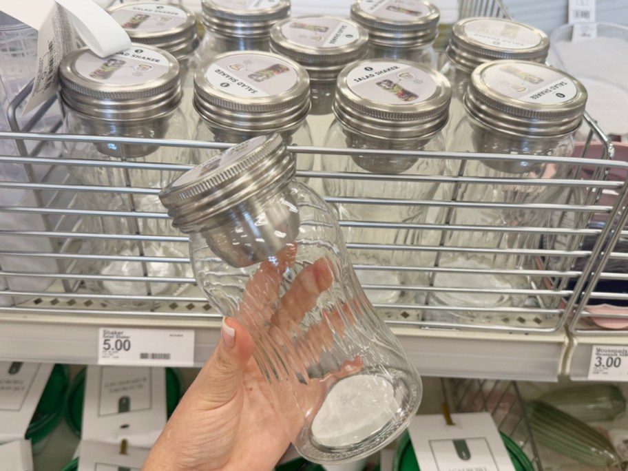 hand holding glass salad shaker 