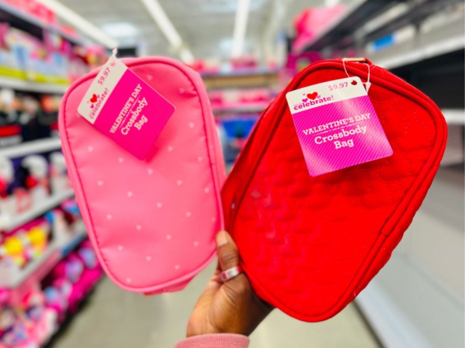 A person holding 2 Walmart Crossbody Bags in Pink and Red