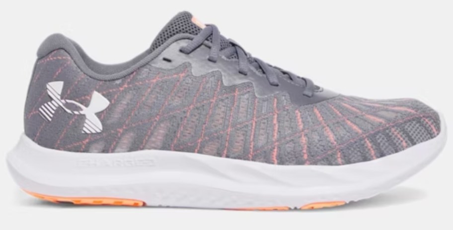 an Under Armour running shoe in grey with orange and white accents