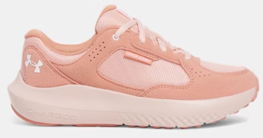 an Under Armour women's running shoe in light and medium pinkish peach colors