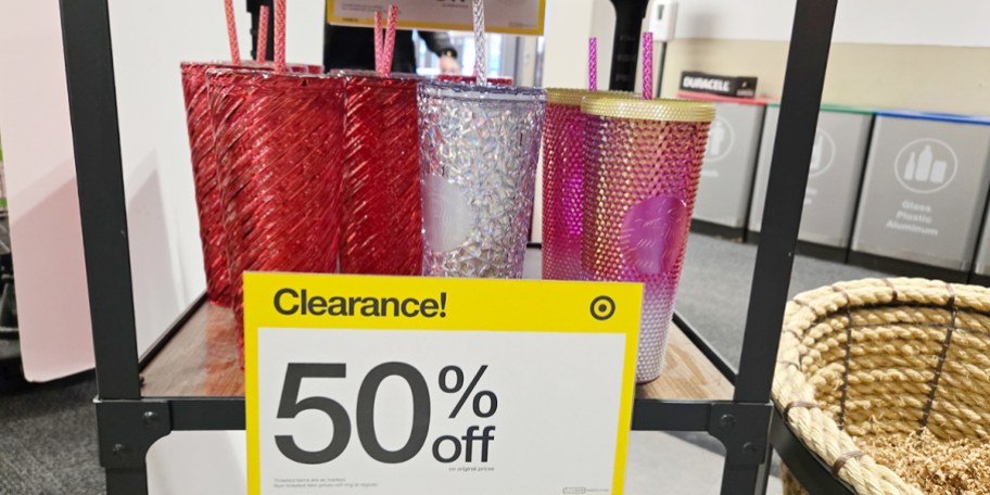 red, clear and pink tumblers on shelf with clearance sign 