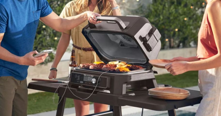 people gathered around Ninja Woodfire Pro Connect Premium XL Outdoor Grill & Smoker outside