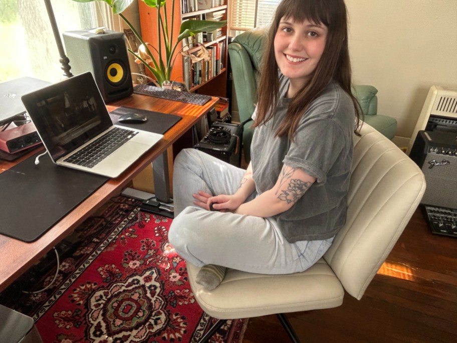 smiling woman sitting cross legged in one of the viral criss cross office chairs