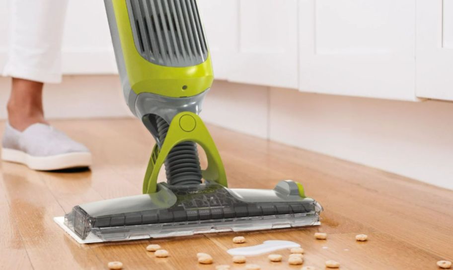 a shark vacmop cleaning up a spilled cheerios on kitchen floor