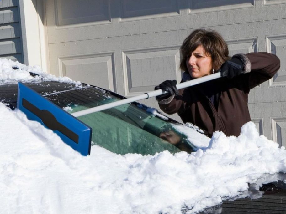 woman using Snow Joe The Original 2-in-1 Telescoping Snow Broom & Ice Scraper on windshield