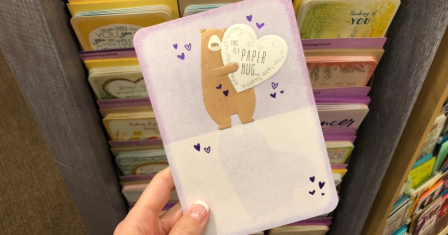 hand holding hallmark card in store with bear on it