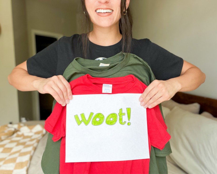 woman holding up woot sign and three t shirts