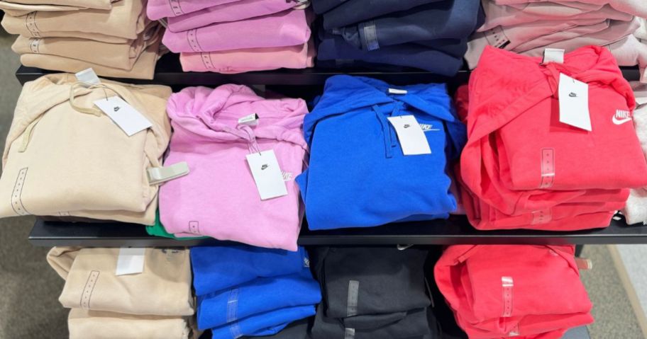 folded nike hoodies in various colors on store display