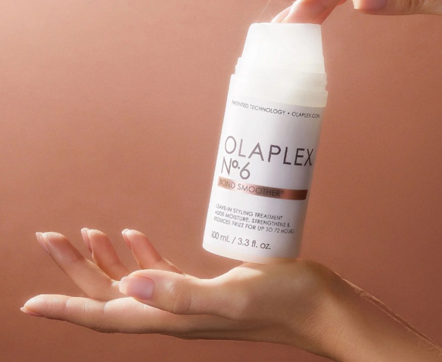 Two hands holding a bottle of Olaplex bond smoother