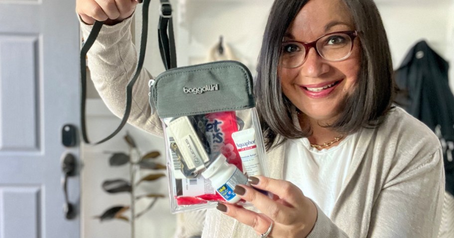 woman holding clear byrant baggallini bag with products inside