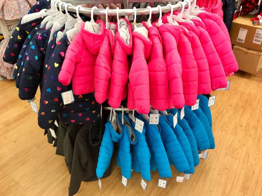 little kids coats hanging on a rack in a store