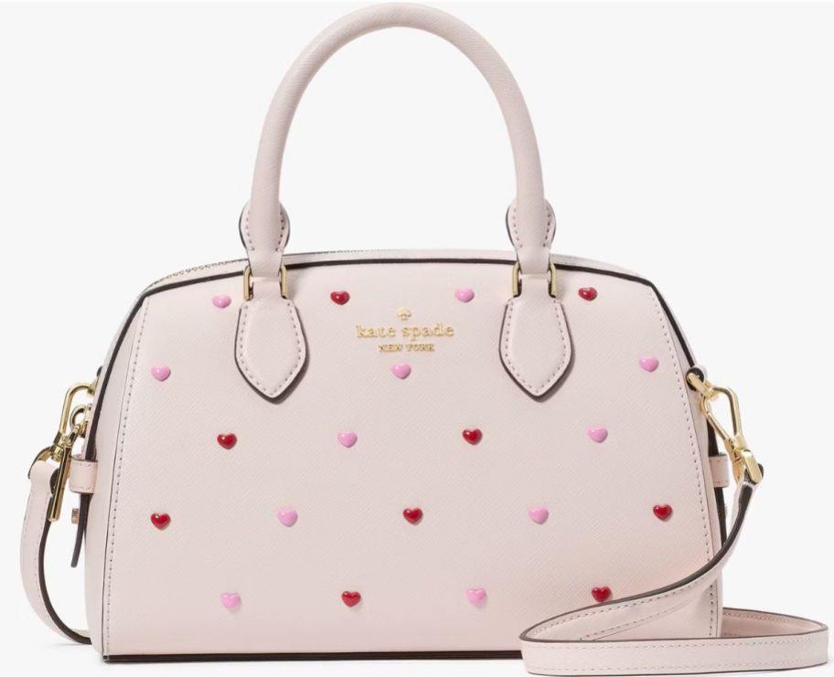 a pale pink top handle bag studded with tiny hearts