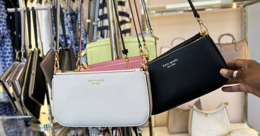 white and black kate spade crossbody bags on display in store