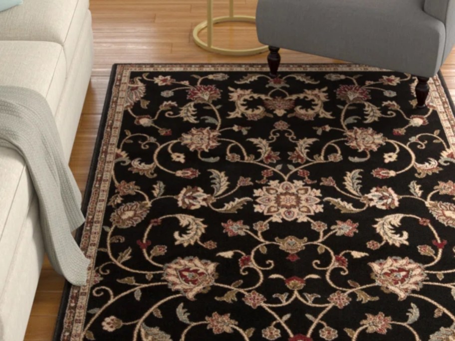 a black cream and red floral print area rug in a living room