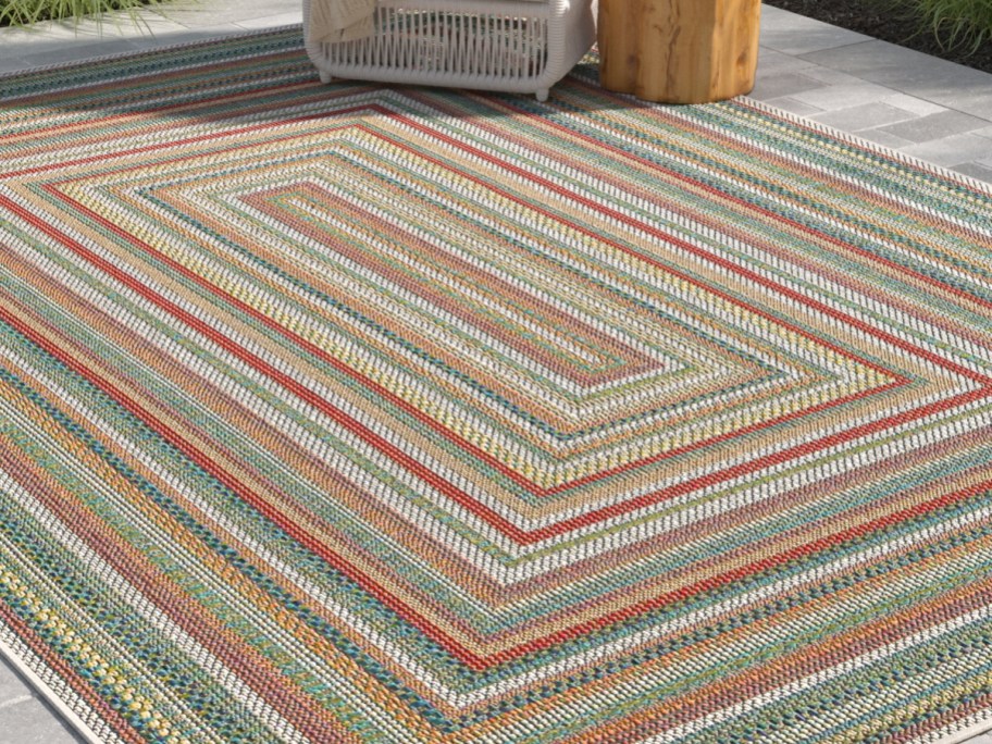 Sand & Stable Lucidia Multicolor Indoor_Outdoor 5x7 Area Rug with a chair on it