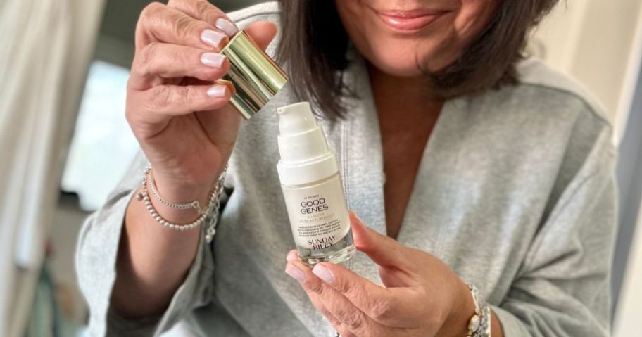 Woman holding a bottle of Sunday Riley Good Jeans Lactic Acid Treatment