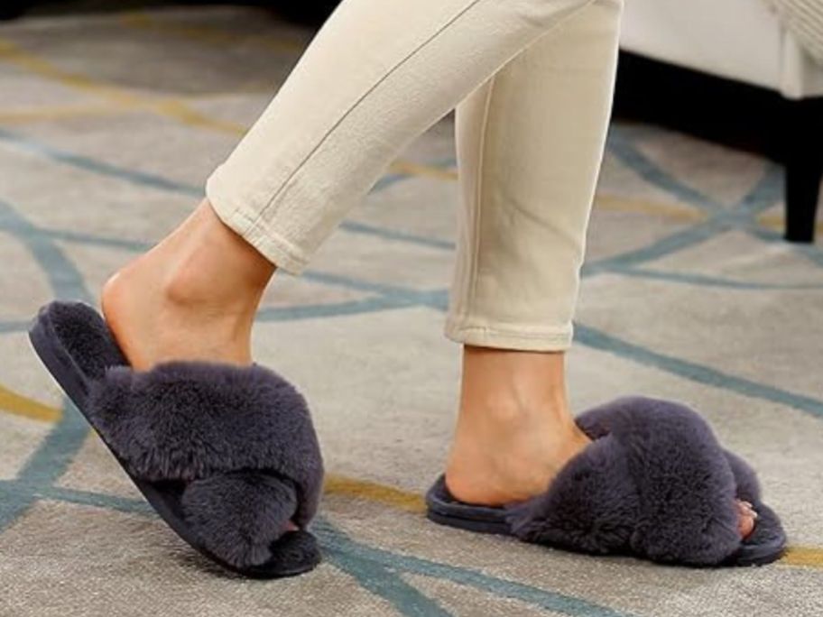 woman's feet wearing parlovable dark gray slippers while walking on a carpet