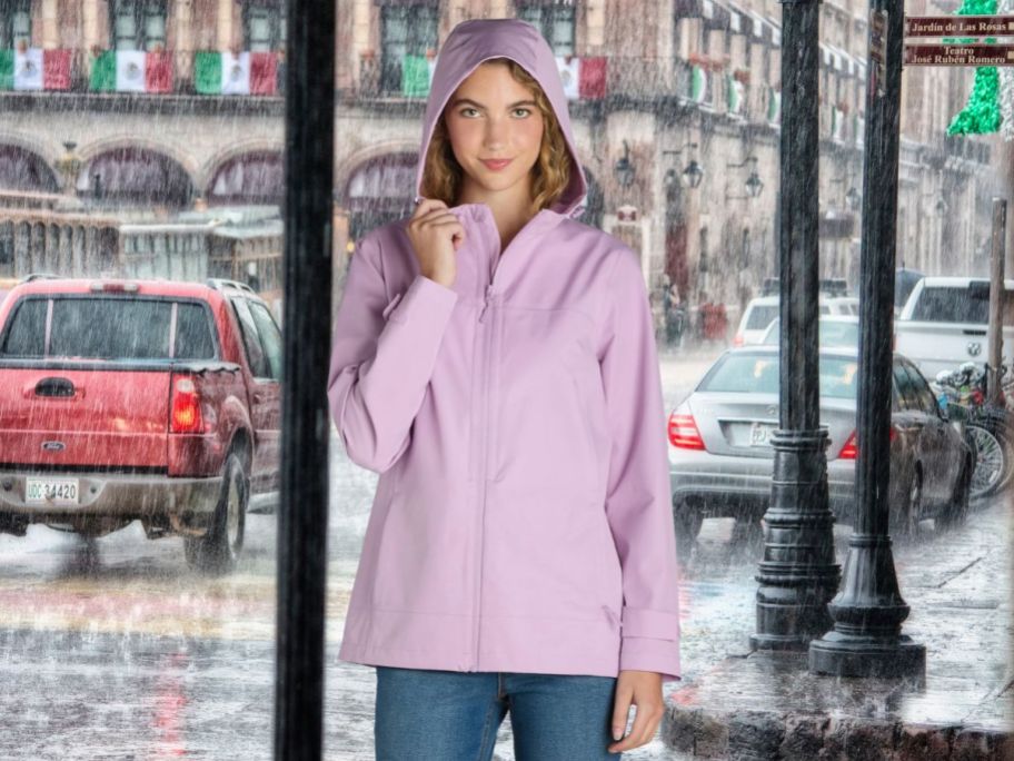 woman standing outside in the rain wearing Time and Tru Women's Waterproof Rain Jacket w/ Hood