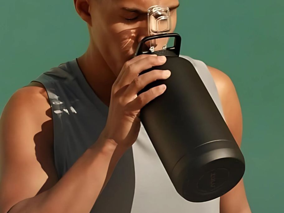 A man drinking from a ZULU Stainless Steel 64-oz Bottle in Black