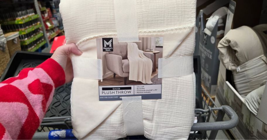 A person holding a gauze blanket in a store