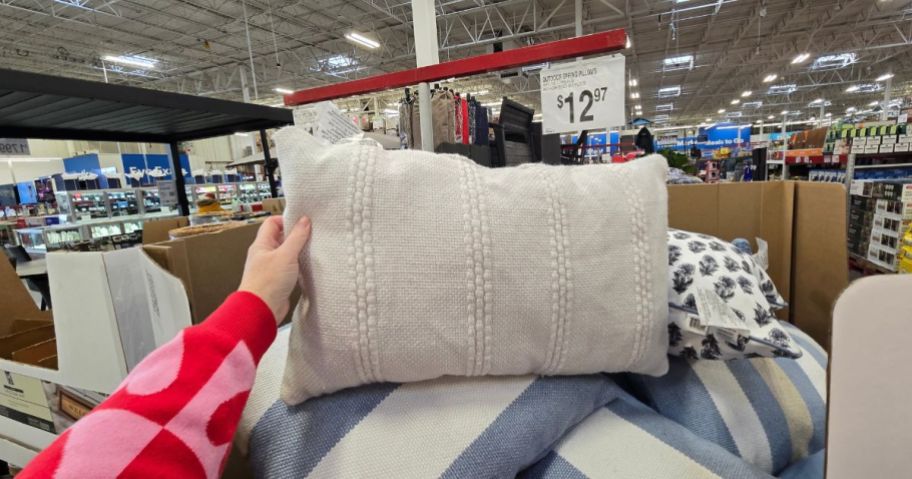 A person holding a throw pillow in a store