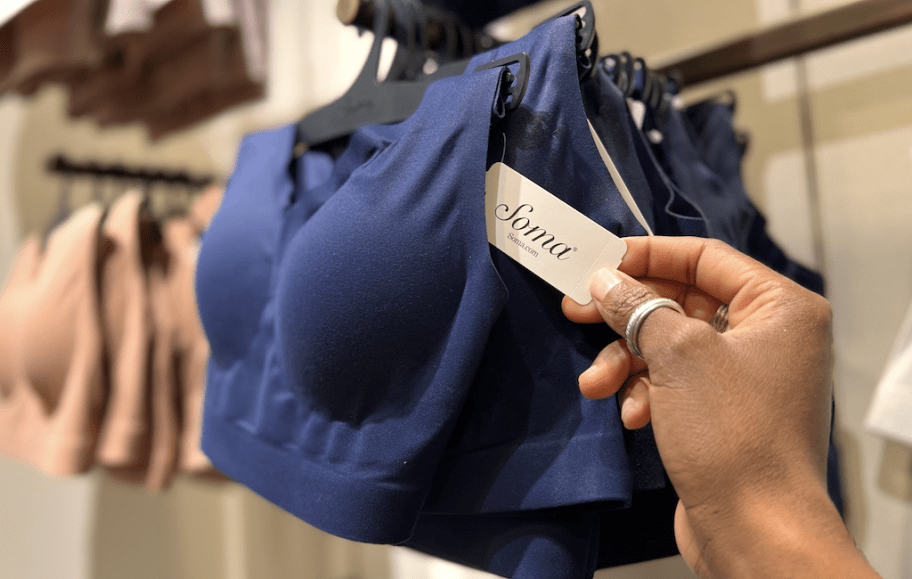 hand holding a soma tag on navy blue sports bra